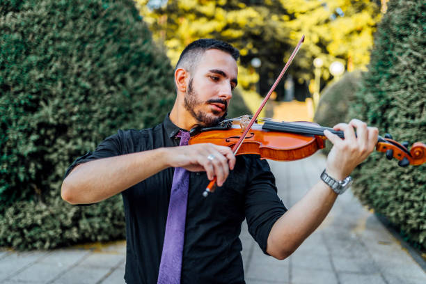 istock Man playing violin outdoors 1389875238