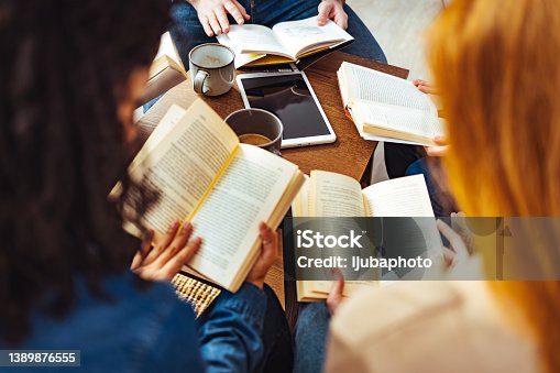 istock Adult students studying together in library 1389876555
