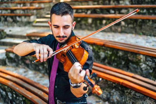 istock Man playing violin outdoors 1389876798