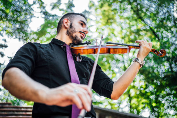 istock Man playing violin outdoors 1389878011