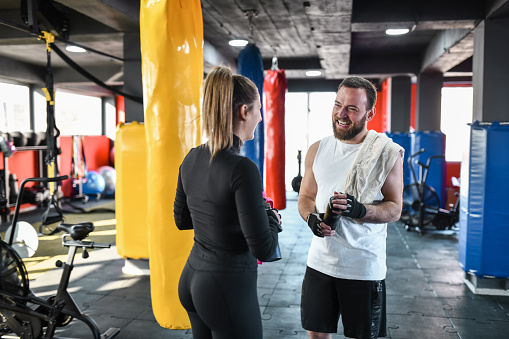 Athletic Couple Enjoying Fresh Drinks After Tough Workout In Gym