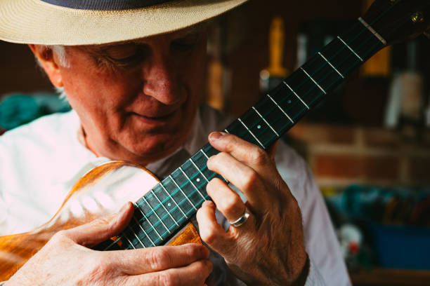 istock Senior man playing ukulele in his garage 1389882850
