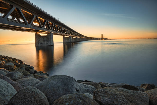 View of Oresund bridge during sunset over the Baltic sea Oresund Bridge, connecting Copenhagen Denmark and Malmo Sweden at sunset oresund bridge stock pictures, royalty-free photos & images