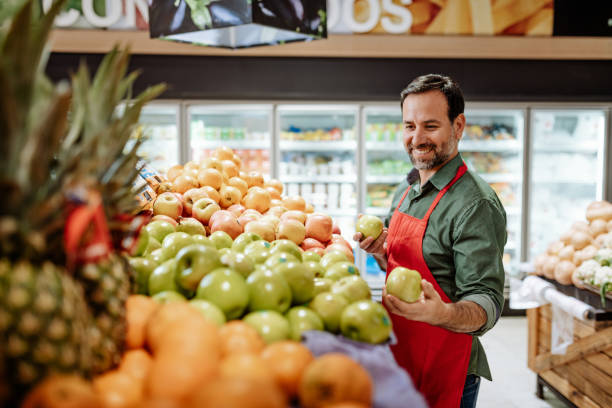 pracownik z ameryki łacińskiej - greengrocer w supermarkecie - warzywniak zdjęcia i obrazy z banku zdjęć
