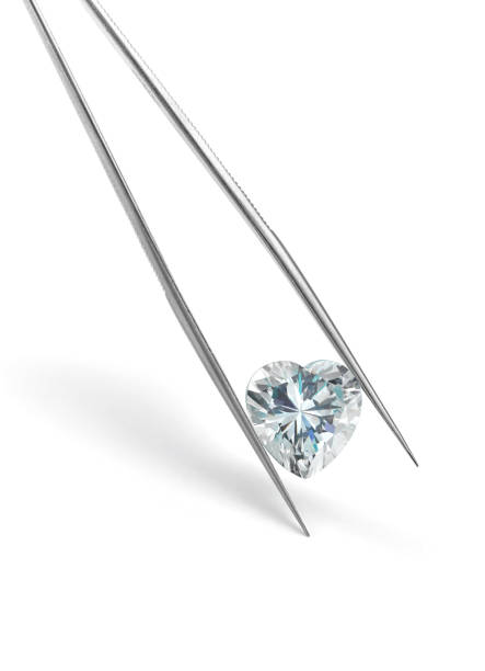 istock Heart Shaped Diamond Held in Tweezers 1389884632