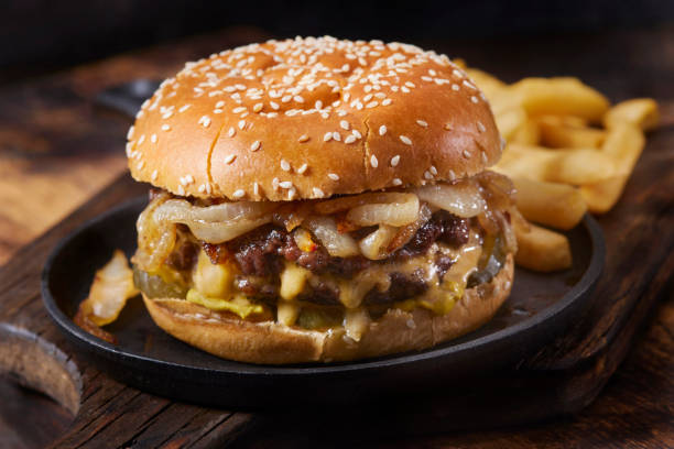 The Juicy Lucy Stuffed Cheeseburger with Fried Onions Two Thin Patties Stuffed with American Cheese and topped with Fried Onions, Pickles and Fries double cheeseburger stock pictures, royalty-free photos & images