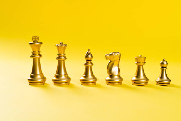 istock A row of chess pieces on yellow background 1389885372