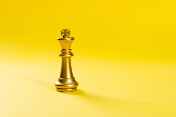 istock Golden king chess piece on yellow background 1389885409