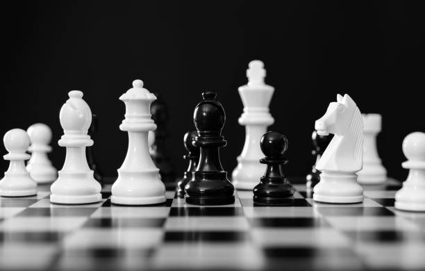 istock Black and white chess pieces battle on the board 1389885471