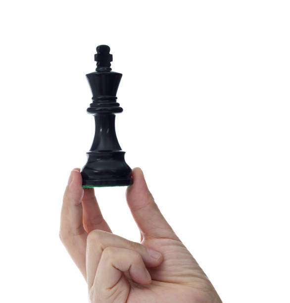 istock Human hand holding chess king on white background 1389885609