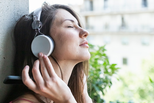 Woman with closed eyes listening to music with headphones