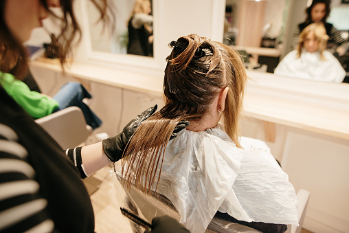 Close-up of a hairdresser dying a female customer hair