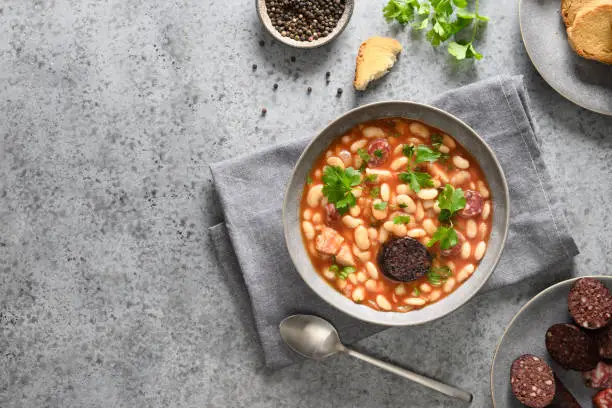 Photo of Spanish asturiana fabada on gray table. Top view.