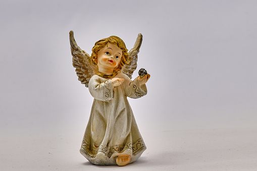 Little Angel with a White Tunic Holds a Sphere in Her Hand