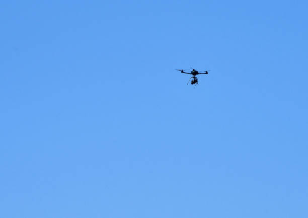 istock Drone in flight isolated against a blue sky 1389888256