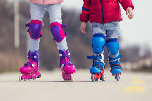 istock Kids boy and girl having fun outdoor while riding roller skates. Children on rollerblades. Roller skating in the park near seashore. 1389888708