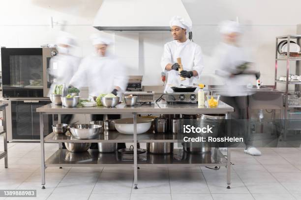Chef Cooks Working In Professional Kitchen Stock Photo - Download Image Now - Commercial Kitchen, Chef, Crowded