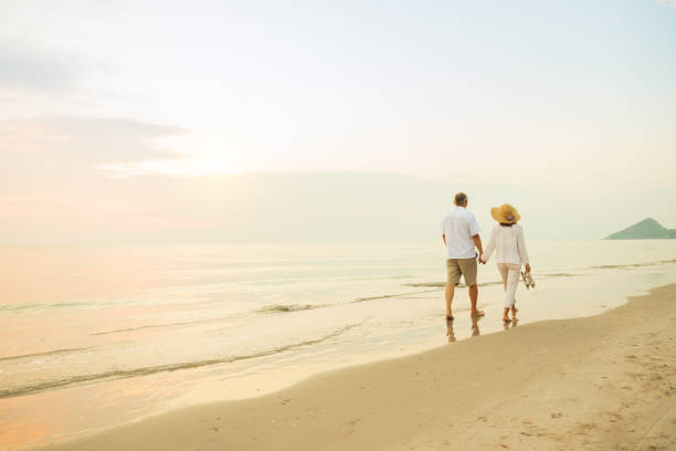 istock Active senior couple walking on the beach 1389890127