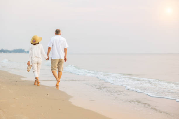 istock Active senior couple walking on the beach 1389890145