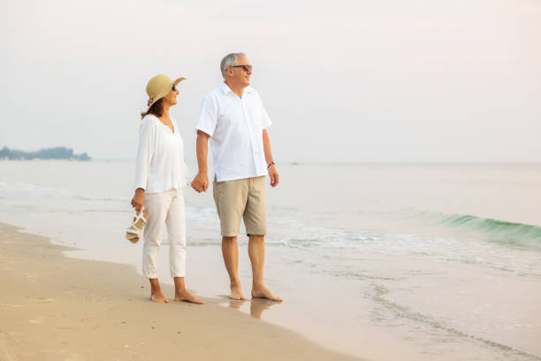 istock Active senior couple walking on the beach 1389890164