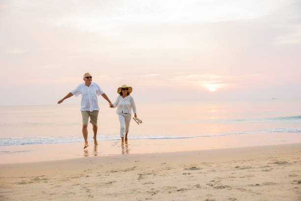 istock Active senior couple walking on the beach 1389890176