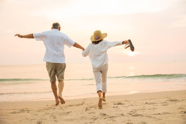 istock Active senior couple walking on the beach 1389890183