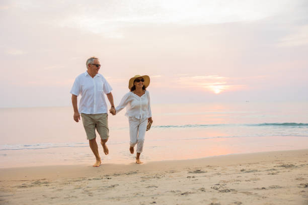 istock Active senior couple walking on the beach 1389890193