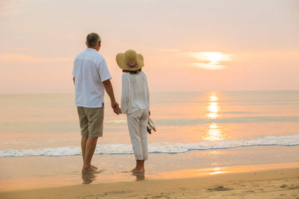 istock Active senior couple walking on the beach 1389890194