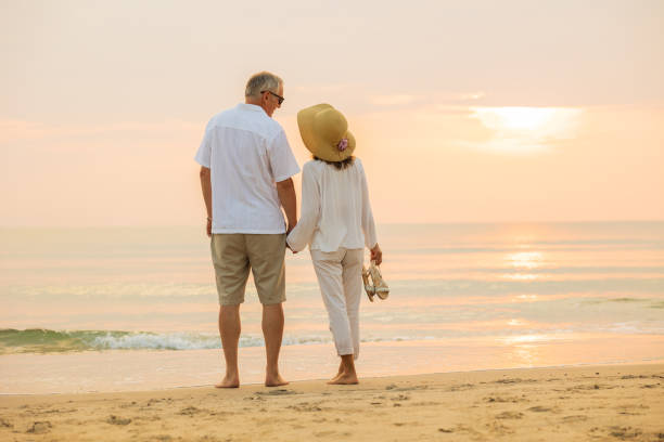istock Active senior couple walking on the beach 1389890206