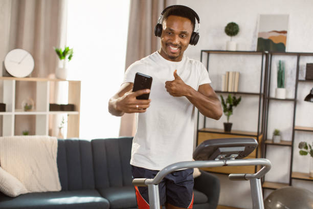 istock Young african american man jogging on the modern treadmill 1389890676