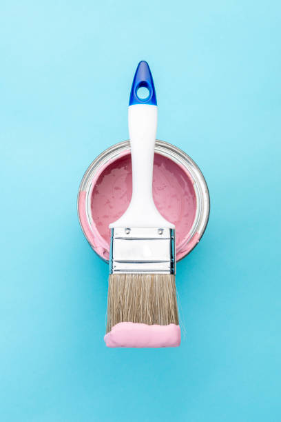 istock Brush on open can of pink paint on blue pastel background 1389892005