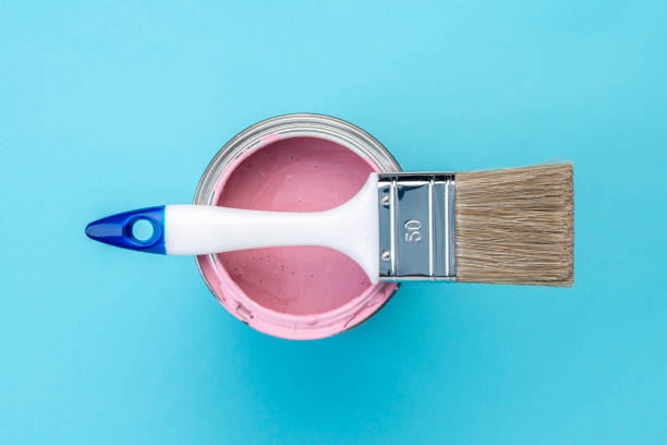 istock Brush on open can of pink paint on blue pastel background 1389892011
