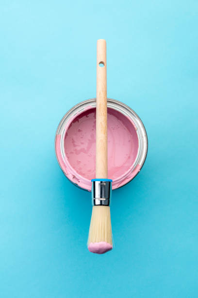 istock Brush on open can of pink paint on blue pastel background 1389892040
