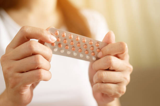 Woman hands opening birth control pills in hand. eating Contraceptive pill. Contraception reduces childbirth and pregnancy concept. stock photo