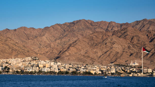 The City of Aqaba The city of Aqaba, Jordan as viewed from the Red Sea.  The flag of the Great Arab Revolt flies over the city. akaba stock pictures, royalty-free photos & images