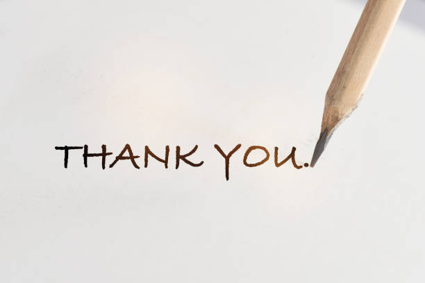 Thank you written on white paper with pencil stock photo