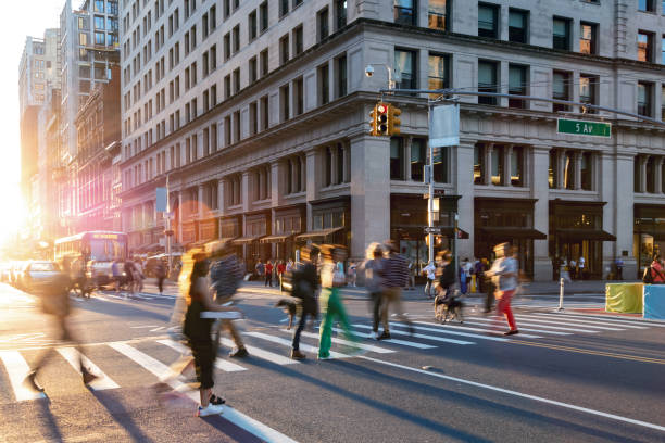 Colorful crowds of people walking through the busy intersection on 23rd Street and 5th Avenue in New York City stock photo