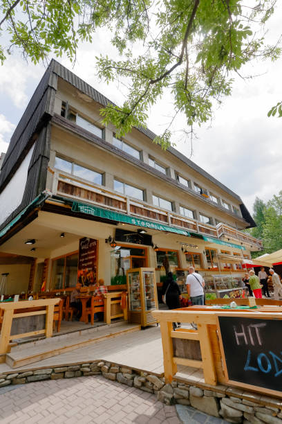 Orbis building on Krupowki street in Zakopane Zakopane, Poland - June 26, 2015: The brick structure of the building, partially covered with wooden elements, refers to the architectural style of the Podhale region. The building was built in 1970 for the needs of a Polish company called Orbis. orbis stock pictures, royalty-free photos & images