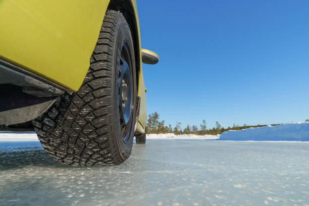 istock Brand new winter tyre on ice surface 1389903663