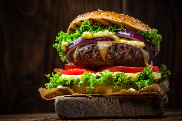istock Grilled Burger with Vegetables on Wooden Background 1389905217