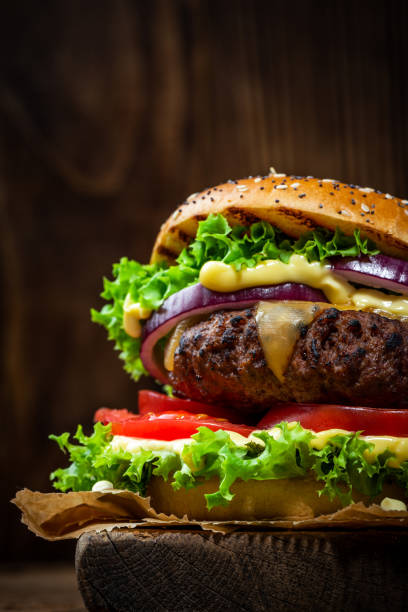 istock Burger Close Up View on Wooden Background 1389905315