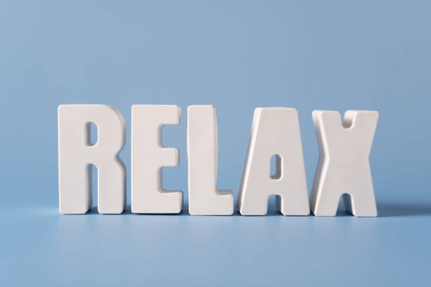 Word Relax made from white concrete letters on the blue background.