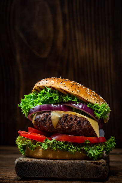 istock Grilled Burger with Vegetables on Wooden Background 1389905619