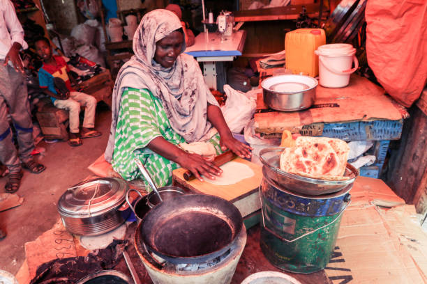 食品市場でピタパンを作る地元の女性 - somaliland ストックフォトと画像