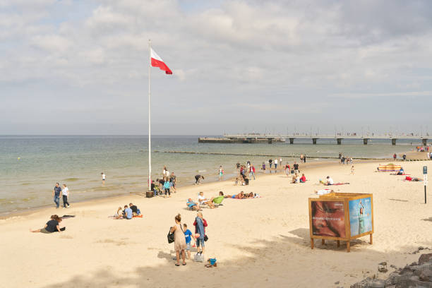 Beach of the Baltic Sea near Kolobrzeg in Poland Kolobrzeg, Poland – September 11, 2021: Holidaymakers on the beach of the Baltic Sea near Kolobrzeg in Poland baltic sea people stock pictures, royalty-free photos & images