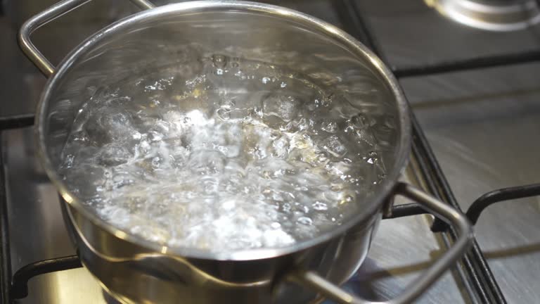 water boils in a saucepan on the burner of the gas stove.