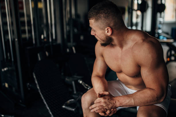 istock Fit man sitting in gym 1389911571