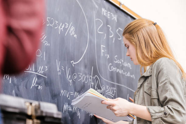 female mathematics major student solving problem on the blackboard - algorithm formula mathematical symbol engineering imagens e fotografias de stock