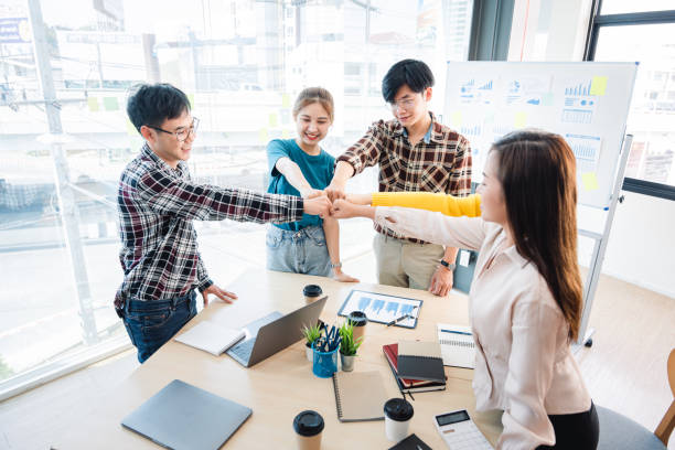 istock young business people putting their hands together. Stack of hands. Unity and teamwork concept. 1389915561