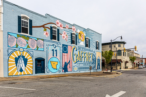 Gaffney, S.C. USA-2 April 2022: Downtown-colorful painted mural showing symbols of the town, and an historic corner building on Limestone Street.